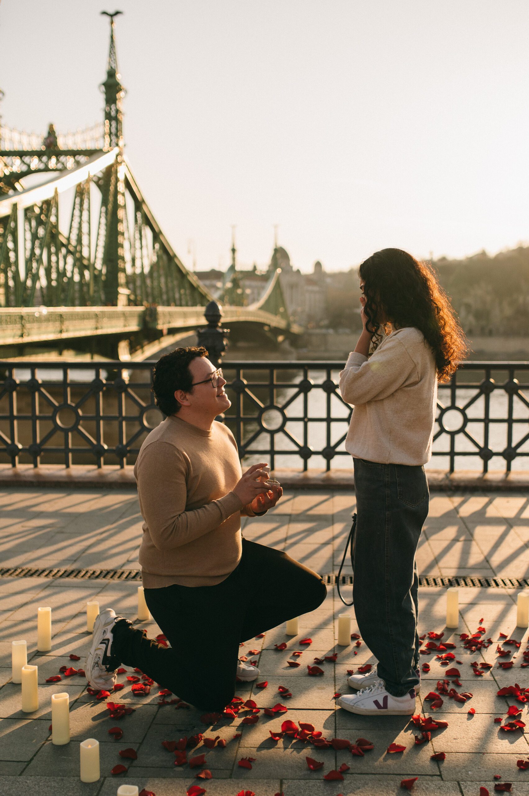 הצעת נישואין רומנטית ליד גשר החירות בבודפשט עם עלי ורדים ונרות {{brizy_dc_image_alt imageSrc=