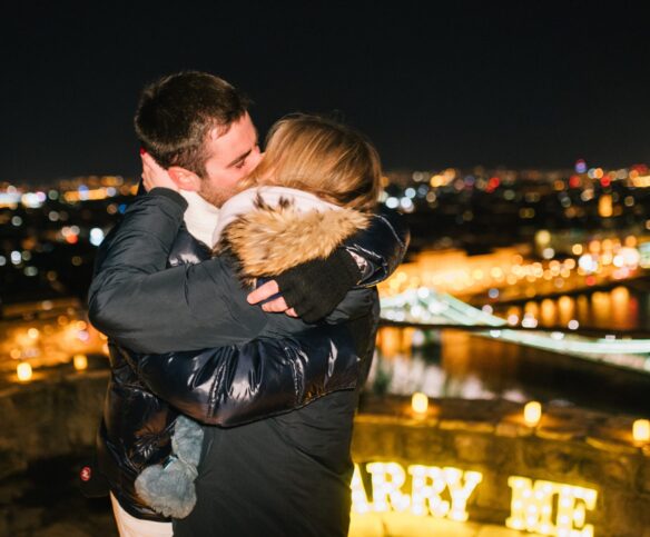 A couple embracing after a marriage proposal photoshoot in Budapest, with a {{brizy_dc_image_alt imageSrc=