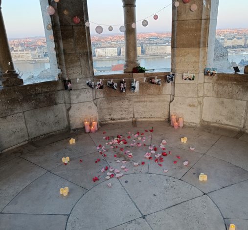 Romantic surprise proposal at Buda Castle with lights, garlands, and photos of the couple under the bastion arch