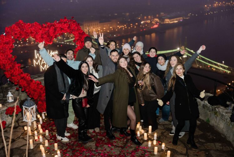 Engagement celebration with friends and family on Gellért Hill in Budapest, overlooking the Liberty Bridge {{brizy_dc_image_alt imageSrc=