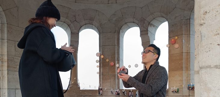 Man holding a ring box during a romantic marriage proposal at Fisherman's Bastion in Budapest